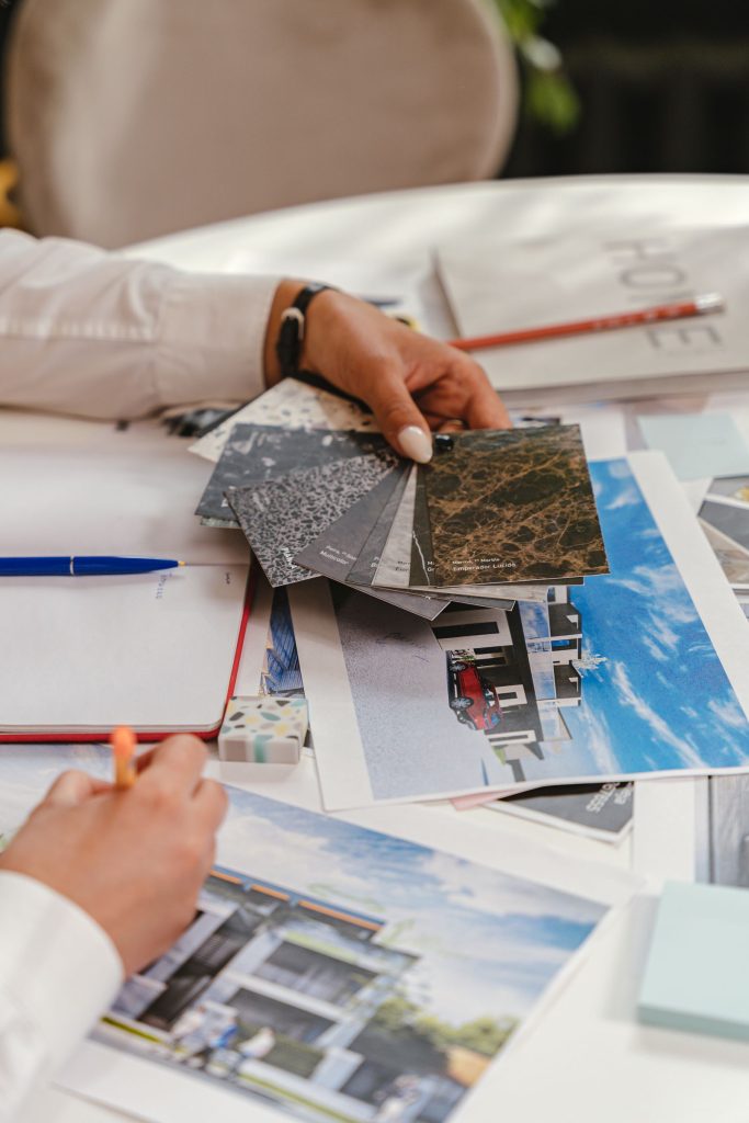 Designer comparing labelled material sample chips over an architectural drawing